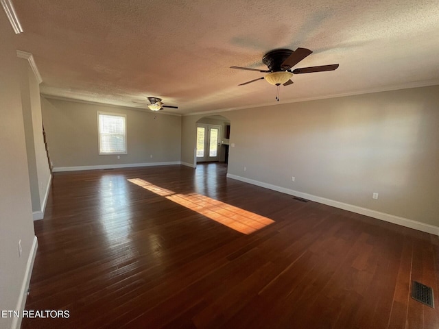 empty room with ceiling fan, ornamental molding, dark hardwood / wood-style flooring, and a textured ceiling