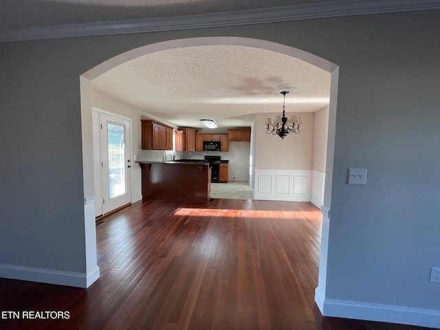 kitchen featuring electric stove, an inviting chandelier, hanging light fixtures, a textured ceiling, and dark hardwood / wood-style flooring