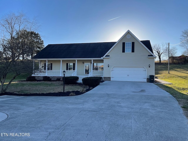 view of front of property featuring a garage, a front yard, and covered porch