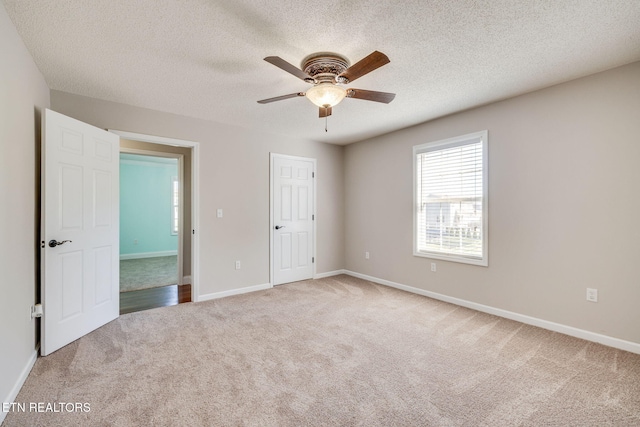 unfurnished bedroom featuring carpet, ceiling fan, and a textured ceiling