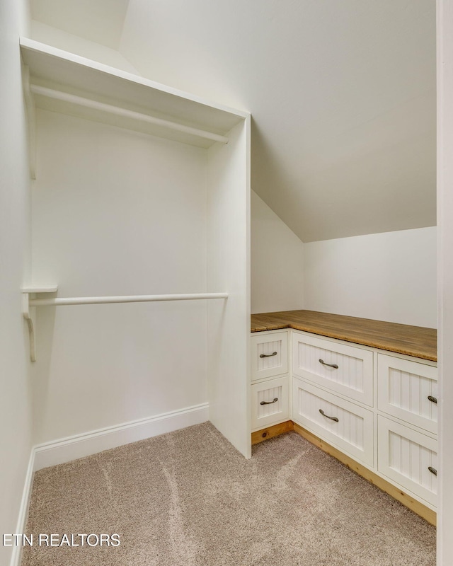 interior space featuring lofted ceiling and light colored carpet