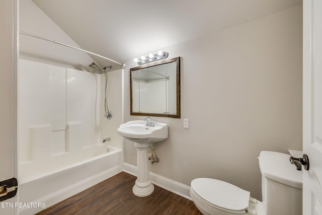 bathroom featuring toilet, hardwood / wood-style flooring, vaulted ceiling, and shower / bathing tub combination