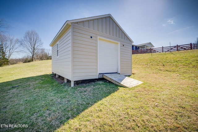 view of outdoor structure with a garage and a lawn