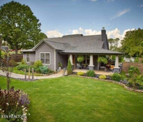 rear view of house with a patio area and a lawn