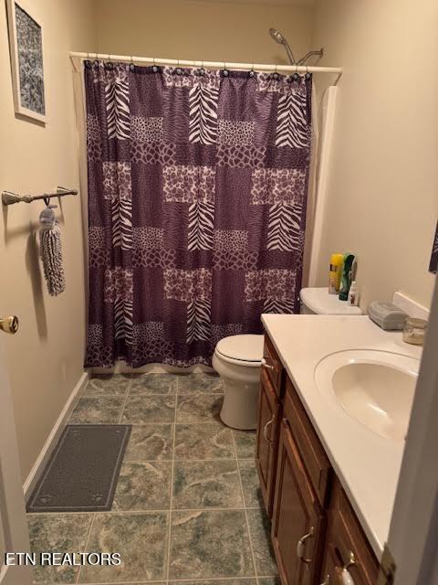 bathroom with vanity, a shower with shower curtain, and toilet