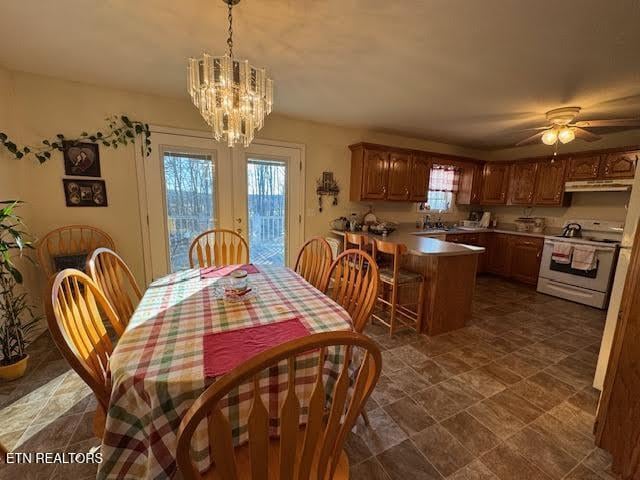 dining area with ceiling fan with notable chandelier