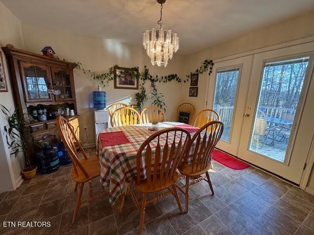 dining space featuring french doors and an inviting chandelier