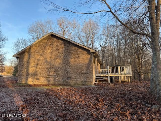 view of property exterior featuring a wooden deck