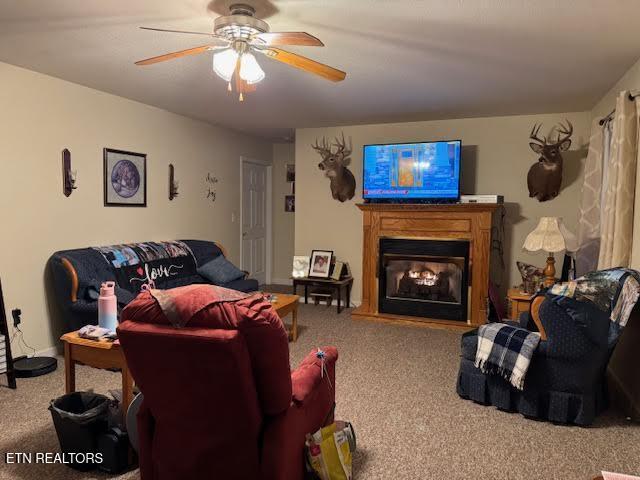 living room featuring ceiling fan and carpet