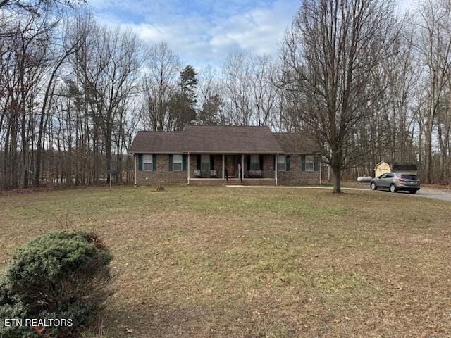 single story home with a porch and a front yard