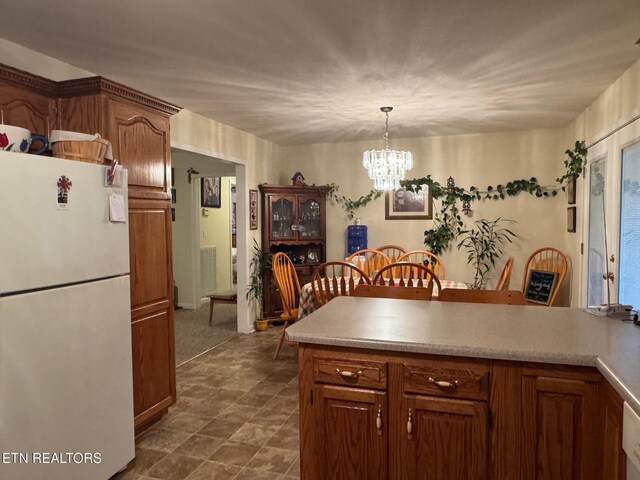 1039 S Ln, Grimsley, TN 38565 - kitchen featuring freestanding refrigerator, a chandelier, hanging light fixtures, light countertops, and brown cabinets