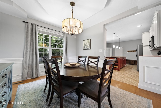 dining room with an inviting chandelier and light hardwood / wood-style flooring