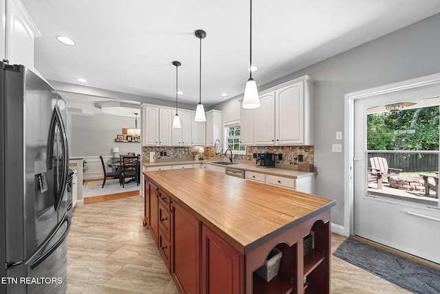 kitchen with sink, white cabinetry, tasteful backsplash, appliances with stainless steel finishes, and a kitchen island