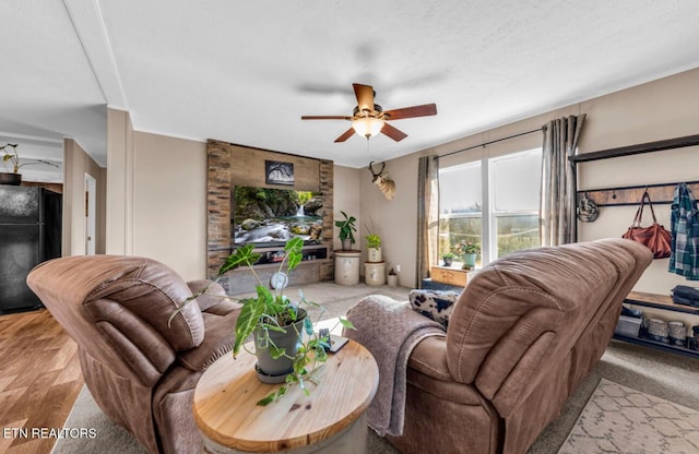 living room featuring light wood-type flooring, a textured ceiling, and ceiling fan