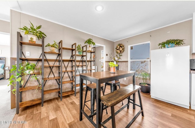 dining area featuring crown molding and light hardwood / wood-style floors