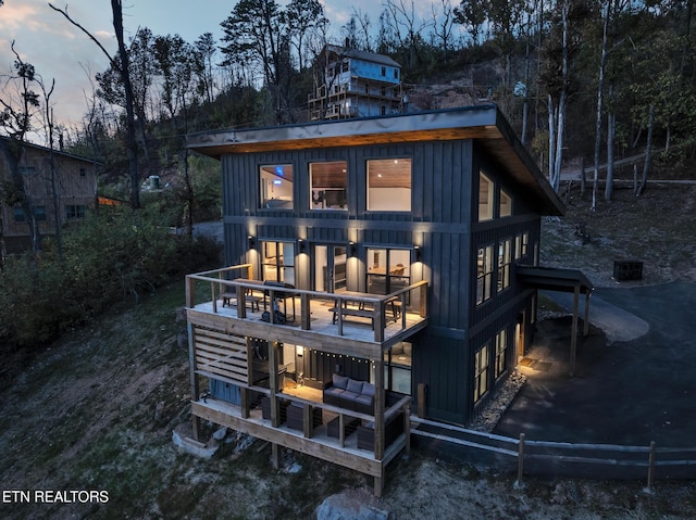 back house at dusk featuring a balcony