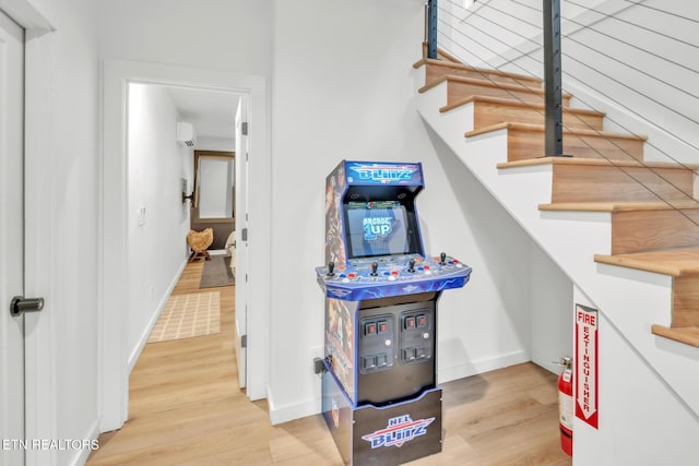 staircase featuring hardwood / wood-style flooring and a wall mounted AC