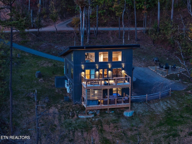 rear view of house featuring a wooden deck and a balcony