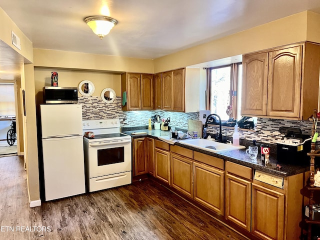 kitchen featuring sink, dark wood-type flooring, white appliances, and decorative backsplash