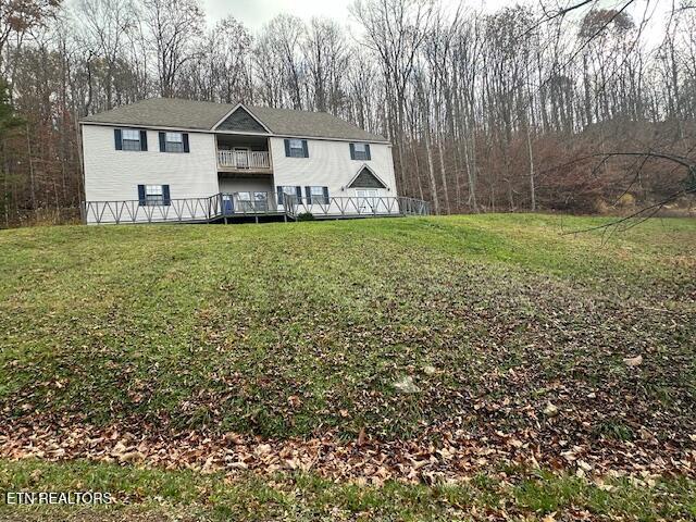 view of front of home featuring a balcony and a front yard