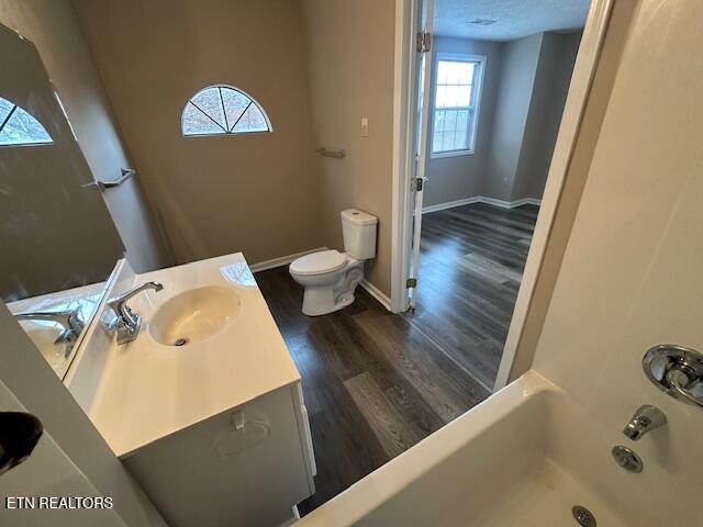 bathroom featuring hardwood / wood-style flooring, vanity, a textured ceiling, and toilet