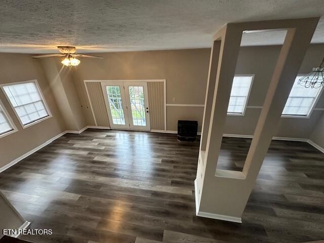 unfurnished room with dark hardwood / wood-style flooring, plenty of natural light, and a textured ceiling