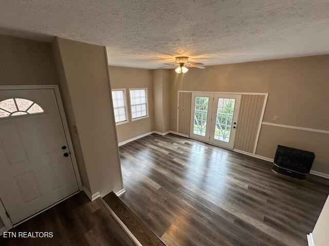 entryway with ceiling fan, dark wood-type flooring, a wealth of natural light, and a textured ceiling