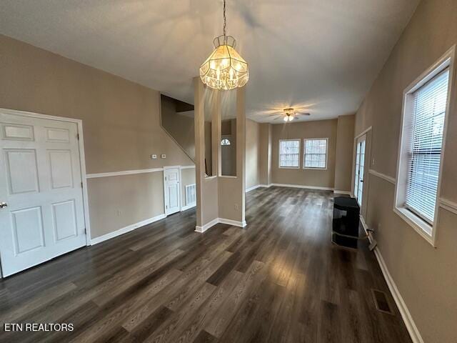 unfurnished living room featuring dark hardwood / wood-style flooring and a chandelier