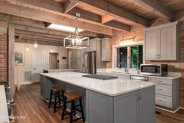 kitchen featuring pendant lighting, sink, dark hardwood / wood-style flooring, a center island, and stainless steel appliances