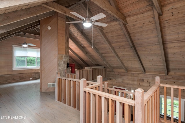 bonus room with lofted ceiling with beams, wood ceiling, wooden walls, and light hardwood / wood-style floors