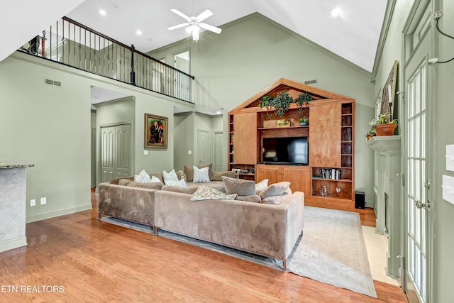 living room featuring ceiling fan, high vaulted ceiling, and light hardwood / wood-style floors