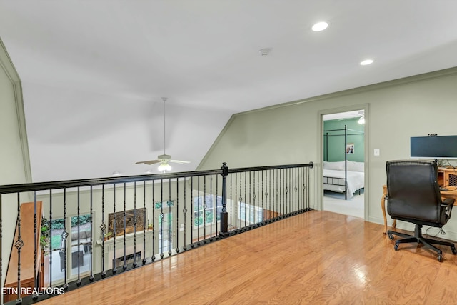 office area featuring wood-type flooring, lofted ceiling, and ornamental molding