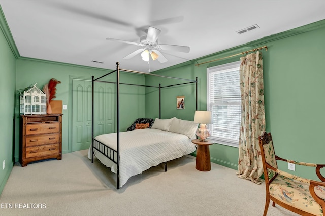 bedroom featuring crown molding, light colored carpet, ceiling fan, and a closet