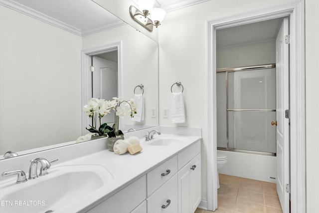 full bathroom with tile patterned floors, toilet, combined bath / shower with glass door, crown molding, and vanity