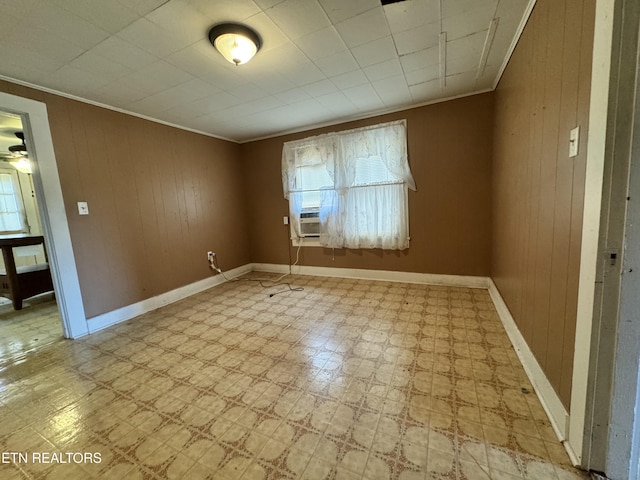 unfurnished room with crown molding, wooden walls, and cooling unit