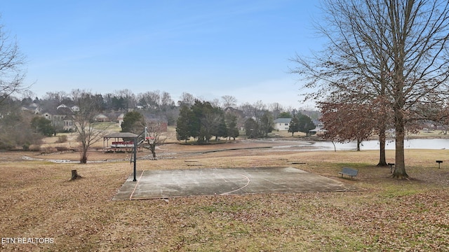 view of yard featuring a gazebo, basketball hoop, and a water view