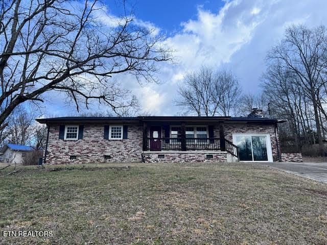 single story home with a porch and a front yard