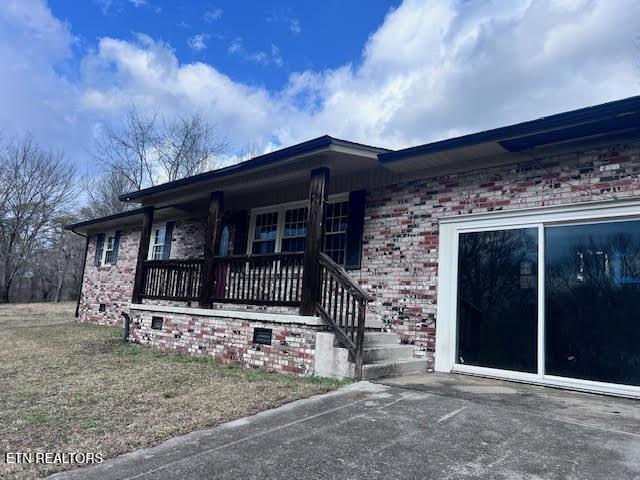 exterior space with covered porch and a front lawn