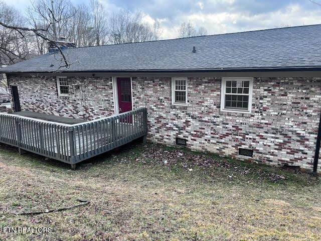 rear view of house with a yard and a deck