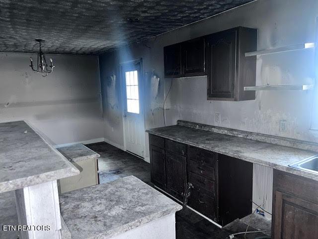 kitchen with dark hardwood / wood-style floors, a chandelier, and decorative light fixtures