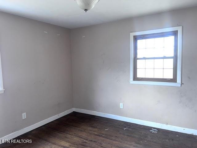 unfurnished room with dark wood-type flooring