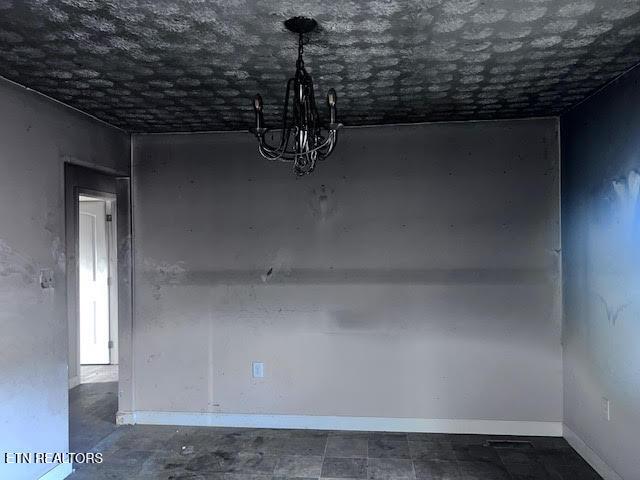 unfurnished dining area featuring a notable chandelier