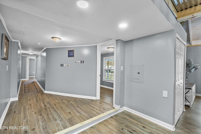 corridor with crown molding, hardwood / wood-style flooring, and electric panel