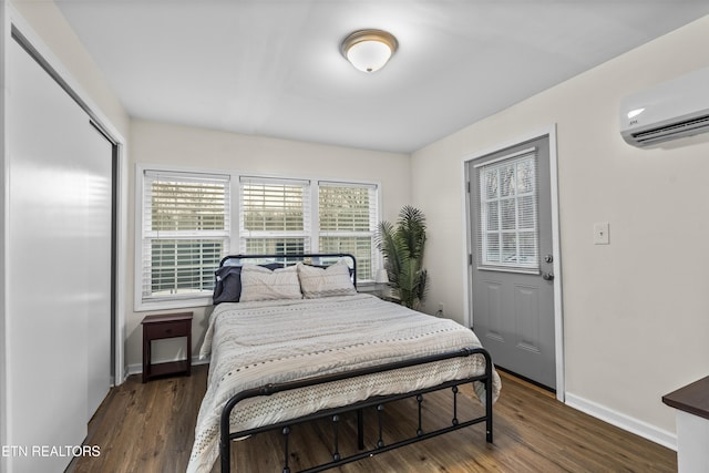 bedroom featuring dark hardwood / wood-style flooring, a wall mounted air conditioner, and a closet