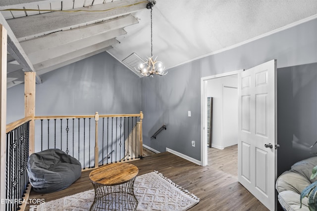 sitting room featuring lofted ceiling, hardwood / wood-style flooring, a textured ceiling, and a chandelier