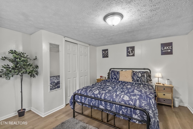 bedroom with hardwood / wood-style flooring, a textured ceiling, and a closet