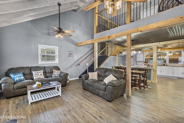 living room featuring lofted ceiling with beams, ceiling fan, and light hardwood / wood-style flooring