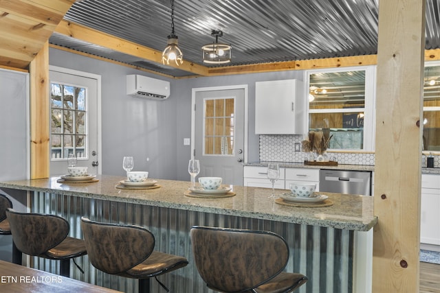 bar with light stone counters, decorative light fixtures, dishwasher, a wall unit AC, and white cabinets