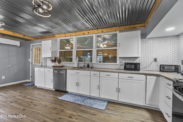 kitchen with stainless steel appliances, a wall mounted AC, and white cabinets