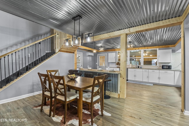 dining space with light hardwood / wood-style flooring and a wall mounted AC